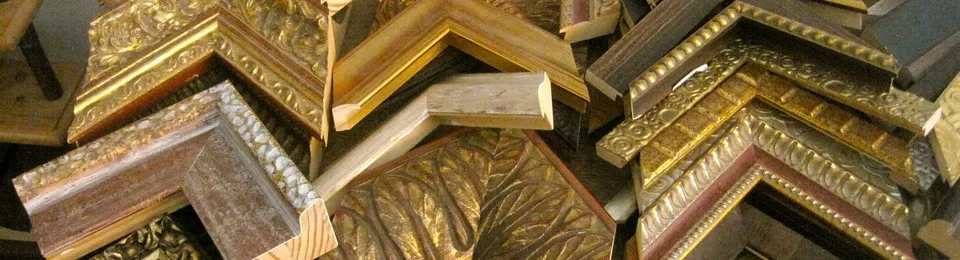 Een stapel lijsthoeken in de werkplaats: verguld, bewerkt met ornamenten en in blank hout